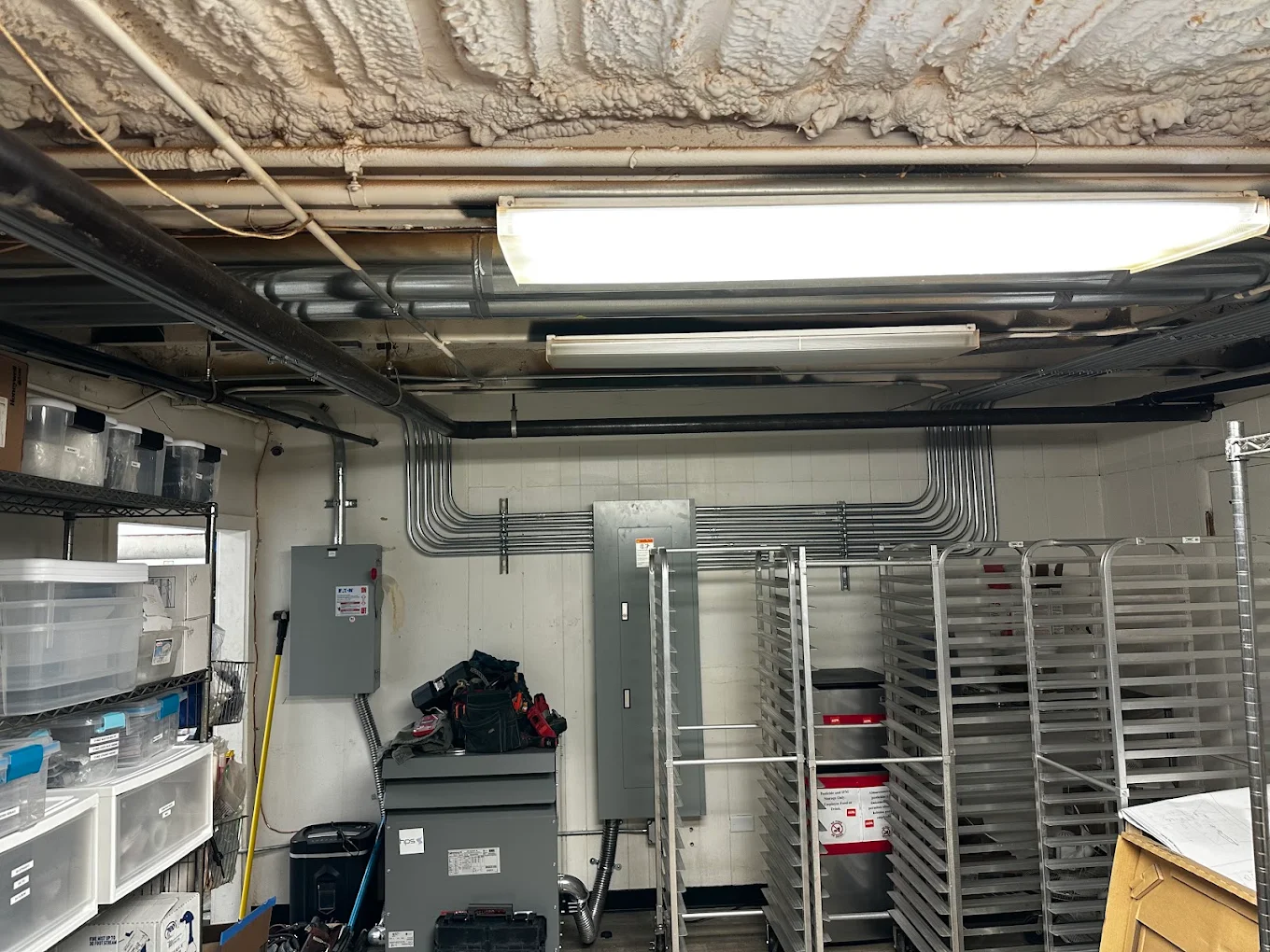 Commercial kitchen ceiling with EMT conduit runs and panel