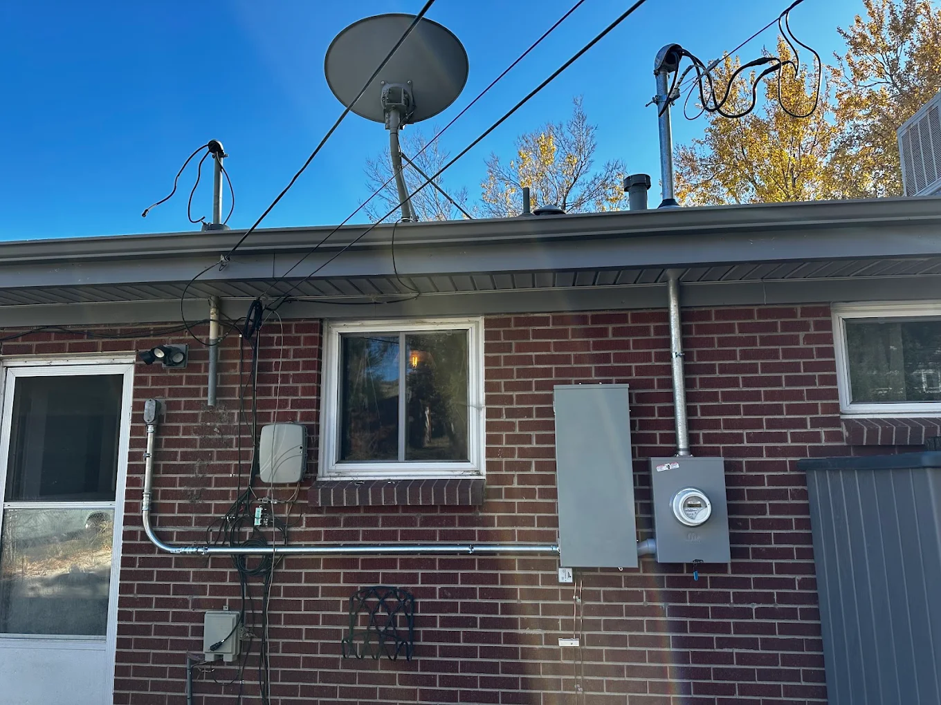 Overhead service riser, meter and disconnect on a brick home