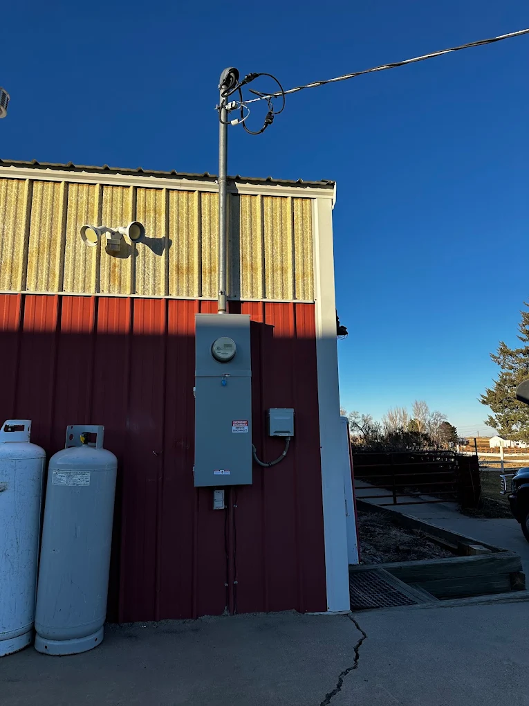 Overhead service mast and meter main on a metal agricultural building