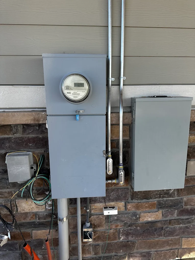 New meter main with rigid conduit risers on a stone-faced home