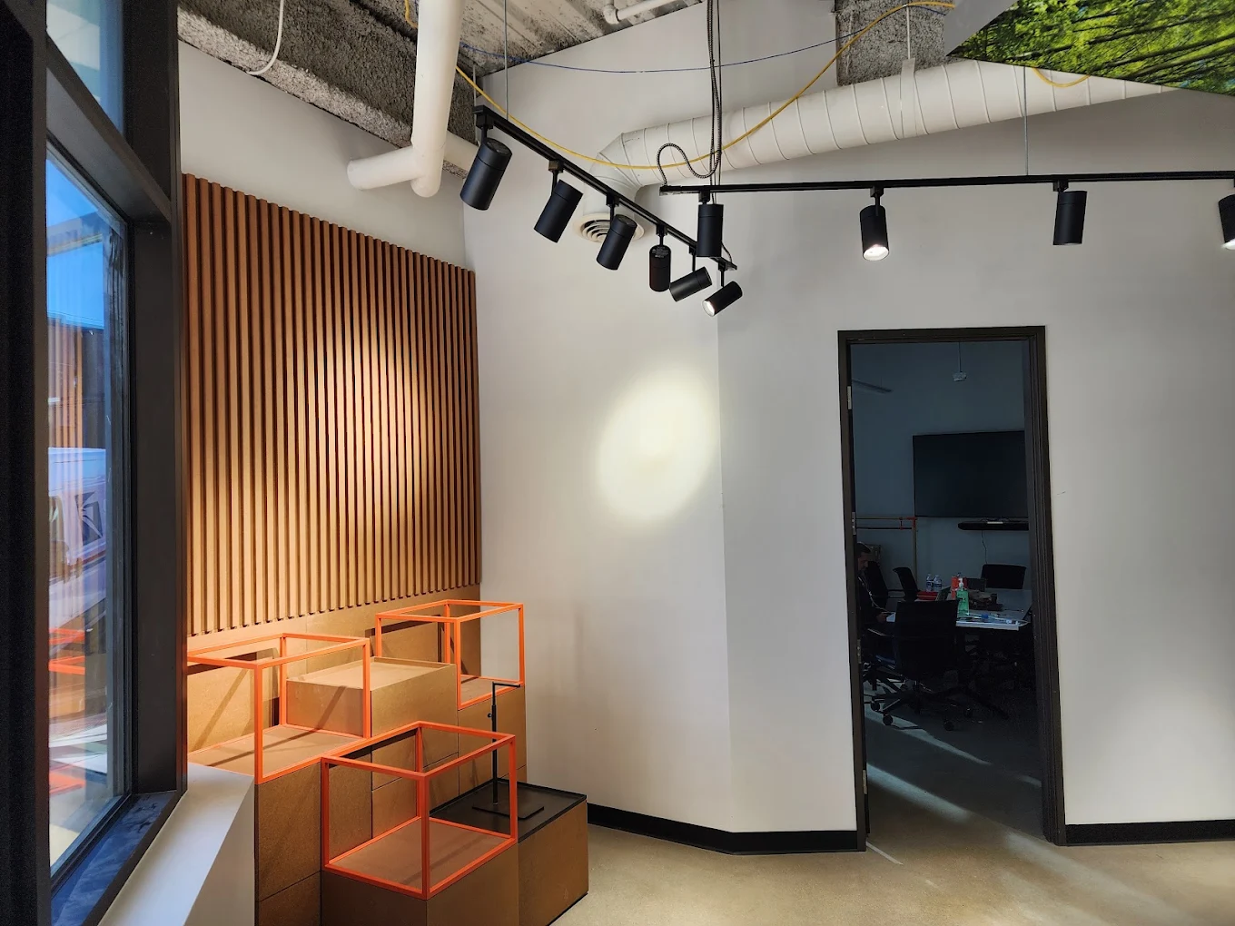 Modern office lobby with black track lighting on exposed ceiling