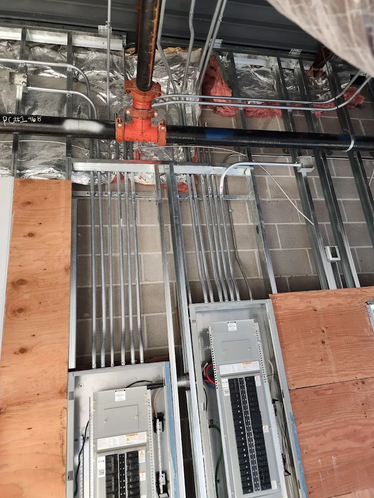 Bank of EMT feeder conduits running to new commercial panelboards