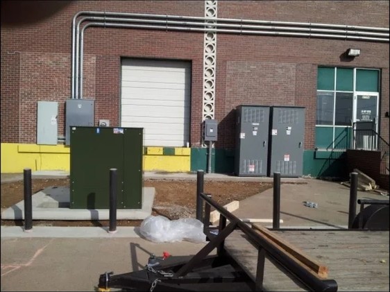 Exterior commercial switchgear and transformer at a brick building
